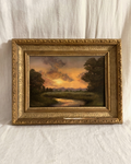 Antique ornate gilt framed original oil painting of a golden and purple sunset over a landscape with trees and a stream.