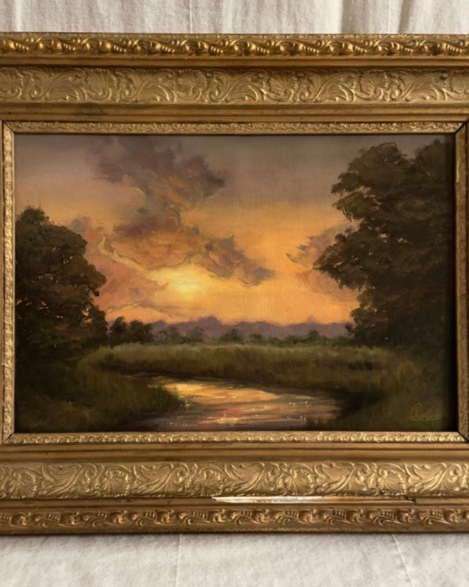 Antique ornate framed original oil painting of a landscape with trees and stream under a golden and purple sunset.