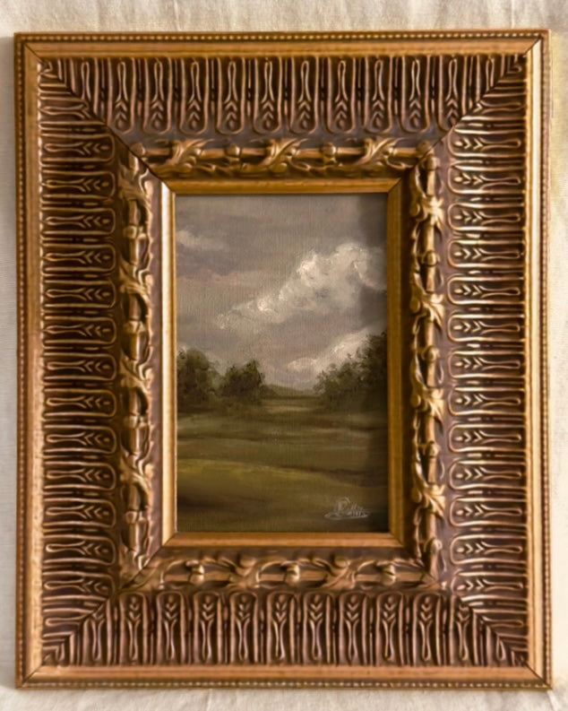Antique ornate gilt framed original oil painting of a moody grey british countryside landscape, zoomed in.