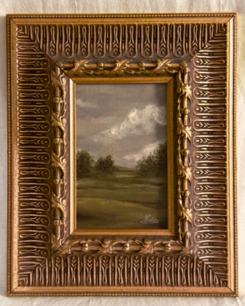 Antique ornate gilt framed original oil painting of a moody grey british countryside landscape, zoomed in.