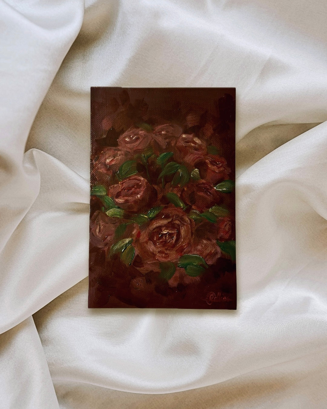Original oil painting, unframed. Deep and rich velvetty red roses with hints of green leaves surrounding on a deep red background. Moody, romantic, cottagecore style painting.